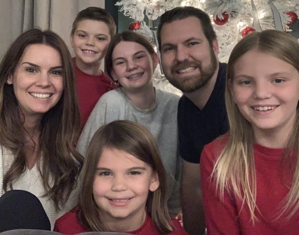 Breck and his family in front of a Christmas tree